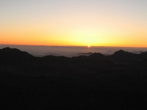The first sign of the sun peeking over the horizon at Mount Sinai