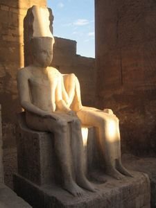 The rays of the setting sun light up the statues in Luxor temple