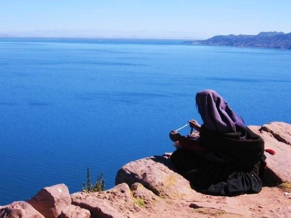 An elderly woman staring out over Lake Titicaca