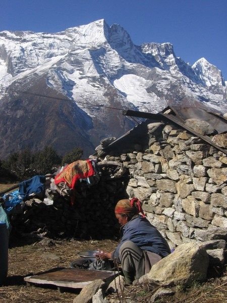 A woman wash clothes at her home in the Himilayas