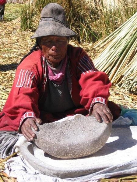 Elderly Woman Grinding Corn