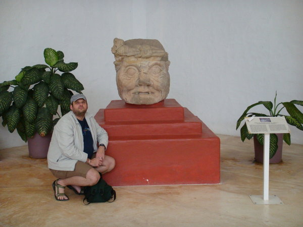 An old man and a Mayan sculpture of one