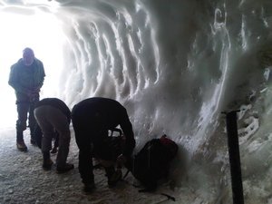 Ice hikiings preparing their gear for a climb exiting via the ice tunnel