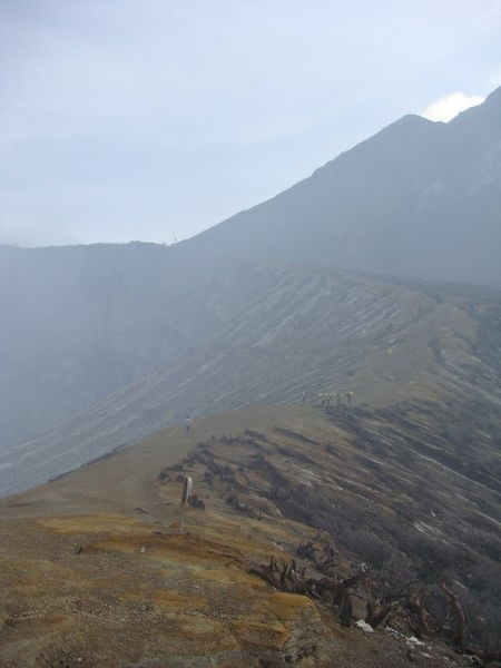 At the top of Kawah Ijen, Java, with sulphur miners walking along the crater rim