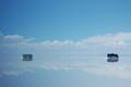 Two busses make their way over the salt flats