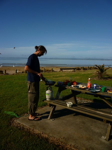 James cooking a breakfast of fried egg sarnies on the beach
