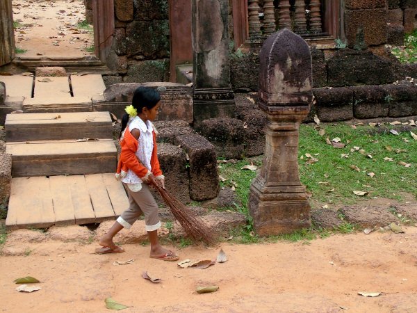 Little girl sweeping the entrance to the temple