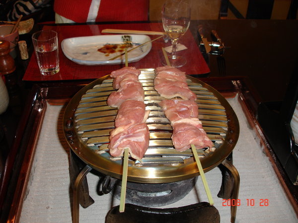 Cooking chicken on small grill at table