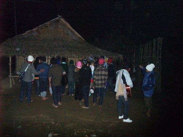 A Christmas carol group singing outside homes in the camp