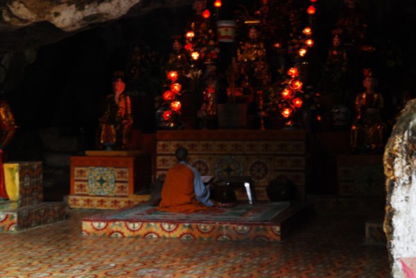 A solitary monk chanting prays inside the Ban Long Temple