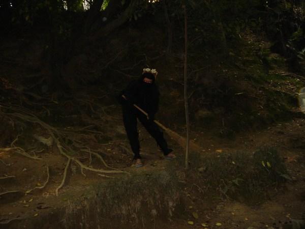 Julia déguisée en ninja passant le balai dans la forêt