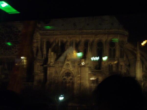 Notre Damn by night and through a moving bus window