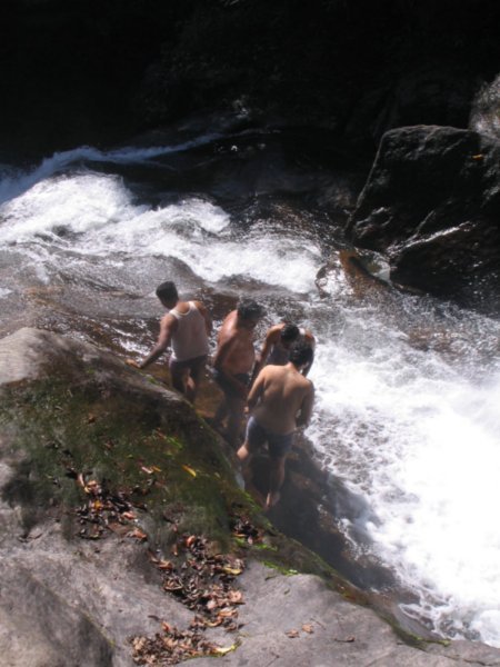 Cold boys bathing at waterfall