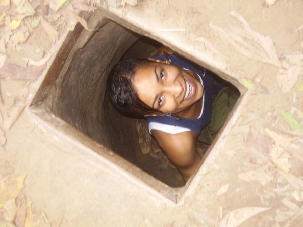 Cara in a hiding hole at the Cu Chi tunnels