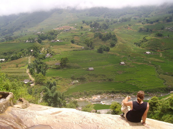 Looking out at the rice terraces from the top of a waterfall
