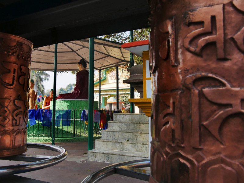 The prayer wheels and statue of Buddha's first sermon